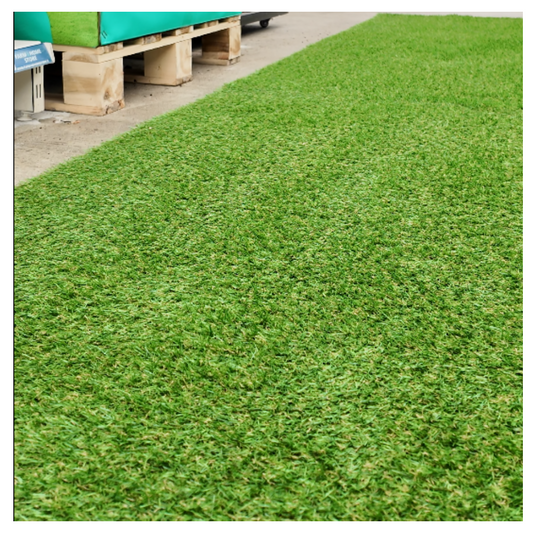 Artificial grass with a concrete edge and wooden pallets in the background