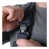 Person adjusting a black seat belt buckle on a gray garment.