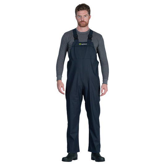 Man wearing a pair of dark blue overalls on a white background