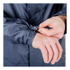 Person adjusting the cuffs of a navy blue jacket on a white background