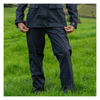 Person wearing dark rain gear standing in a grassy field