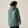 Person wearing a green raincoat on a beige background