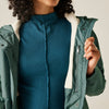 Person wearing a green jacket with a white interior on a neutral background