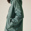 Green raincoat with a brand logo on a beige background