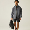 a man wearing an open grey waterproof jacket with black shorts and holding a black backpack