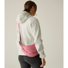 A woman shown from the back wearing a white hooded jacket and black leggings, with a pink crossbody sling bag worn around her waist against a plain light beige studio background.