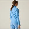 a woman facing away from the camera wearing a blue denim half zip fleece with blue shorts on an off white background