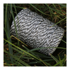 Black and white spool of thread on grass