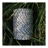 Spool of black and white rope in a grassy area