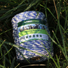 A spool of Farmstokk fencing poly wire, 200m x 3mm, wrapped in blue and white stripes, resting on green grass.