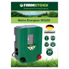 A Farmstokk Mains Energiser M1200 electronic fence controller shown on a white background with a branded header card. The controller is dark green with gray side panels, a small display window, and red and black controls.