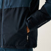 Close-up of a dark blue jacket with a brand logo on the sleeve against a neutral background
