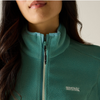 Close-up of a person wearing a teal fleece zip-up jacket with a light blue inner collar and a small white Regatta Great Outdoors logo on the chest.