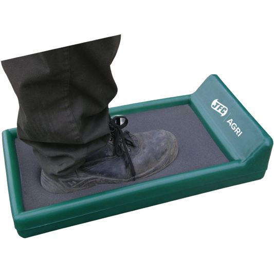 A green and gray TFS AGRI walk-through floor detector with a person's leg and boot stepping on it, shown against a plain white background.