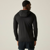 A man viewed from the back wearing a black hooded athletic jacket with a small orange accent lining the hood, paired with dark shorts, against a plain light gray studio background.