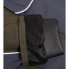 Close-up detail of a garment cuff showing an olive green fabric sleeve with a black textured mesh lining over a dark gray or black padded section, set against a navy blue quilted fabric background.