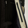 Close-up of a black and beige jacket with a zipper, featuring the brand 'Patagonia'.