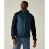 A man wearing a Patagonia hooded zip-up jacket with a quilted blue front panel and dark navy sleeves, paired with blue pants, against a plain beige studio background.