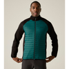 A man wearing a lightweight zip-up puffer vest with a teal quilted front and black sleeves, standing against a solid light beige background.