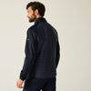 Man wearing a navy quilted jacket on a light background