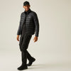 Man wearing a black puffer jacket and pants on a beige background
