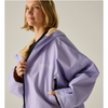 A woman wearing a light purple hooded jacket with a tan fleece lining and black zipper details, shown against a plain beige studio background. The jacket has a visible REGATTA OUTDOOR logo on the chest.