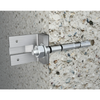 A stainless steel wall anchor with a flat mounting plate, shown installed against a textured concrete wall.