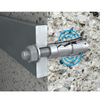 A close-up of a metal wall anchor bolt with a nut and washer, shown embedded against a textured concrete wall. A blue circular graphic overlay highlights the anchor surface.