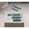 Four metal wall anchors and two hanging hooks arranged on and around a concrete block against a concrete floor.