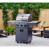 Gray barbecue grill on a patio with greenery and outdoor furniture in the background