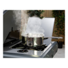 Stainless steel pot on a portable stove with steam rising, outdoor setting.