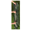 A long, narrow green mesh or fabric bag with a drawstring end, being held open by hands outdoors on grass.