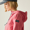 A woman wearing a light gray hooded athletic jacket with pink and black side strings photographed against a plain light gray studio background.