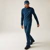Man wearing a blue pullover and pants with a cap on a light background