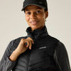 Person wearing a black puffer vest and cap with a visible brand logo on a neutral background