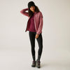 Person wearing a pink jacket, maroon shirt, black leggings, and hiking boots on a white background