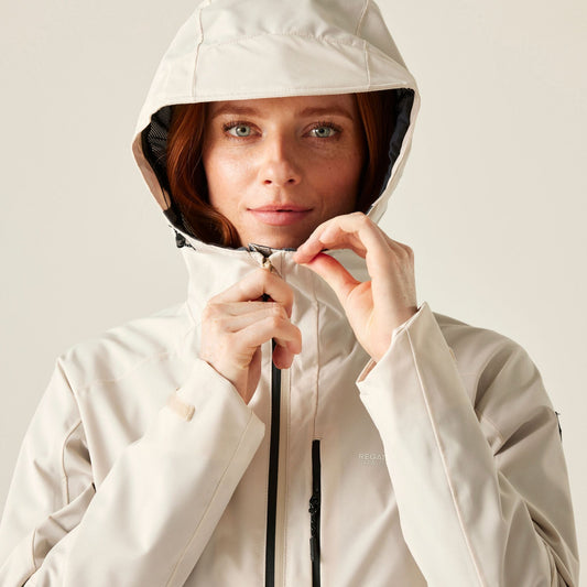 Person wearing a beige hooded jacket on a plain background
