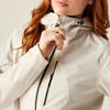 Person wearing a beige jacket with a brand logo on a light background