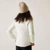 Person wearing a white quilted jacket and beige beanie on a plain background