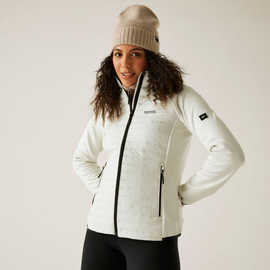 Woman wearing a white jacket with visible branding on a plain background