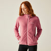 Woman wearing a pink fleece jacket on a plain background