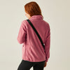 Person wearing a pink fleece jacket on a plain background