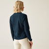 Person wearing a dark blue sweater and white pants against a plain background