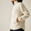 Person wearing a cream-colored fleece jacket against a plain background