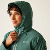 Person wearing a green raincoat with a visible brand logo on a plain background