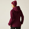 Person wearing a maroon jacket and matching beanie on a beige background