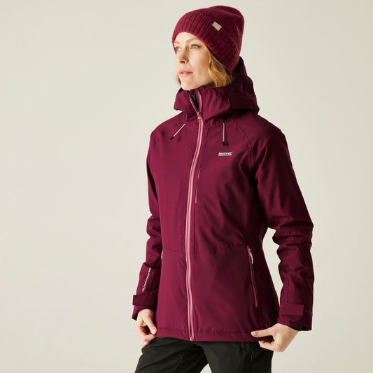 Person wearing a maroon jacket and matching beanie on a beige background