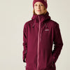 Person wearing a maroon jacket with a brand logo on a plain background
