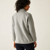 Person wearing a gray fleece jacket on a plain background