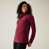 Woman wearing a maroon long-sleeve shirt with a brand logo on a plain background